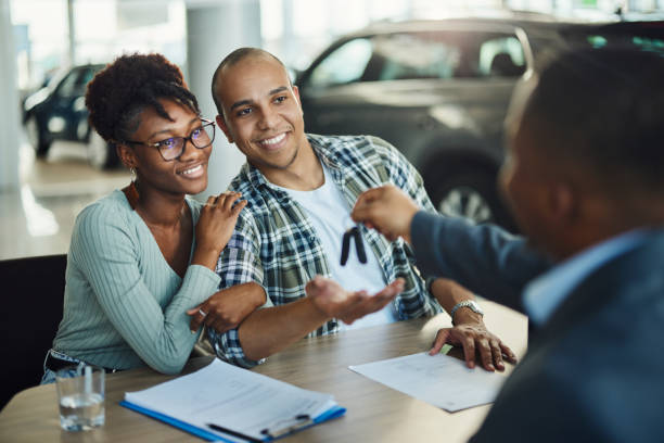 car dealer handing over car keys to the new owners