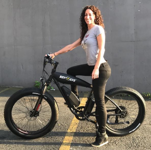 woman on a a white top and black tight on an electric bike